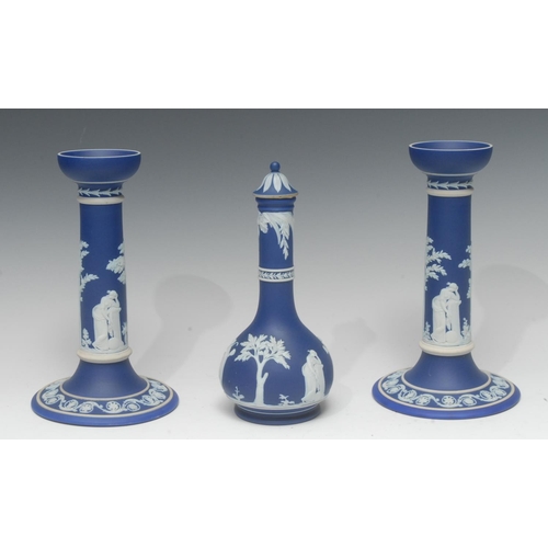 56 - A pair of Wedgwood Jasperware candlesticks, typically sprigged in white with classical figures, 21cm... 