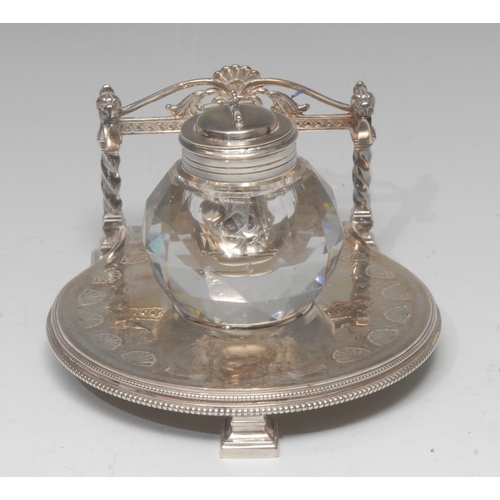 590 - A Victorian E.P.N.S. inkwell stand, facet cut globular well, the stand engraved with anthemions, pen... 