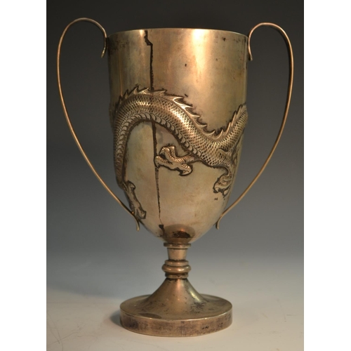 667 - A Chinese silver presentation cup, repousse chased with a ferocious dragon, scroll handles, domed ci... 