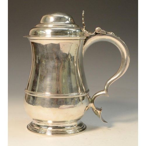 676 - A George II silver baluster tankard, hinged domed cover with cast thumbpiece centred by a heart moti... 