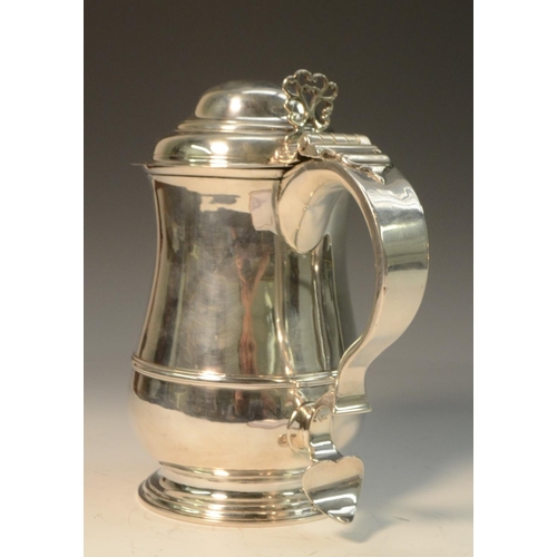 676 - A George II silver baluster tankard, hinged domed cover with cast thumbpiece centred by a heart moti... 