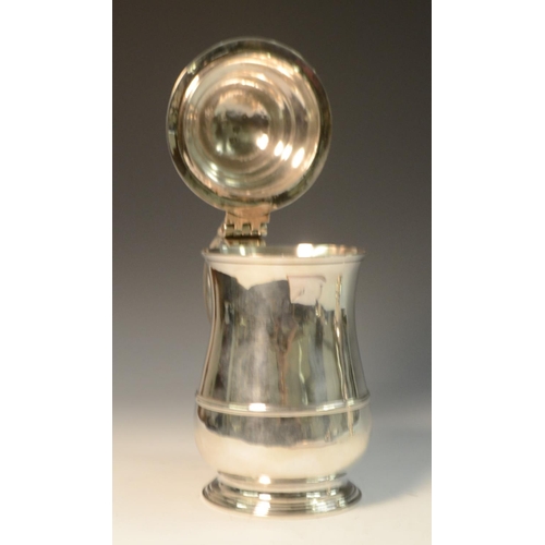 676 - A George II silver baluster tankard, hinged domed cover with cast thumbpiece centred by a heart moti... 