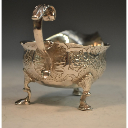 678 - A George II silver cream boat, chased in the Rococo taste with flowers and C-scrolls, acanthus-cappe... 