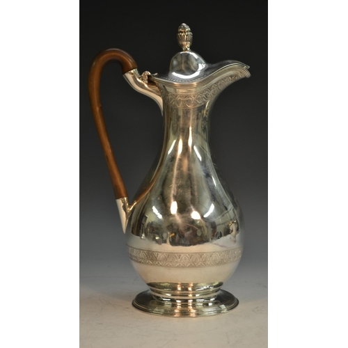 685 - A George III silver baluster wine jug, hinged cover with bud finial, bright-cut engraved with bands ... 