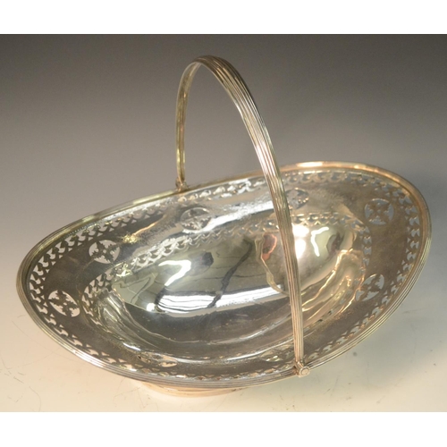 688 - A George III silver boat shaped swing-handled cake basket, pierced and bright-cut engraved with a br... 