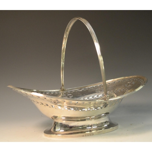 688 - A George III silver boat shaped swing-handled cake basket, pierced and bright-cut engraved with a br... 