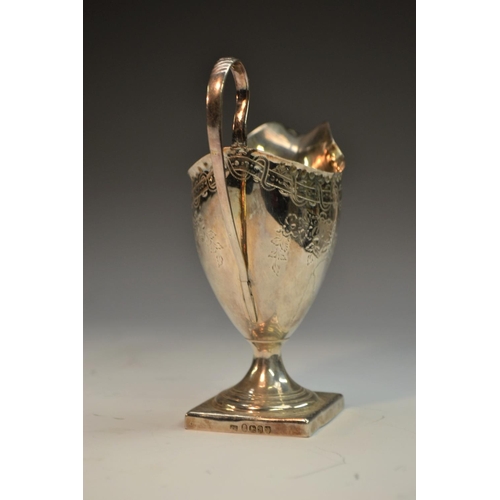 697 - A George III silver helmet shaped cream jug, punch beaded border, bright-cut engraved with patera an... 