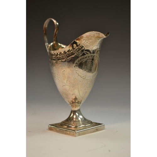 697 - A George III silver helmet shaped cream jug, punch beaded border, bright-cut engraved with patera an... 