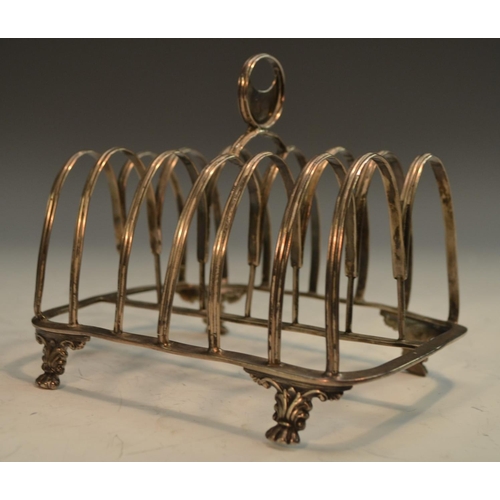 700 - A George III silver seven bar toast rack, crescent-pierced handle, reeded twin-arch divisions, paw f... 