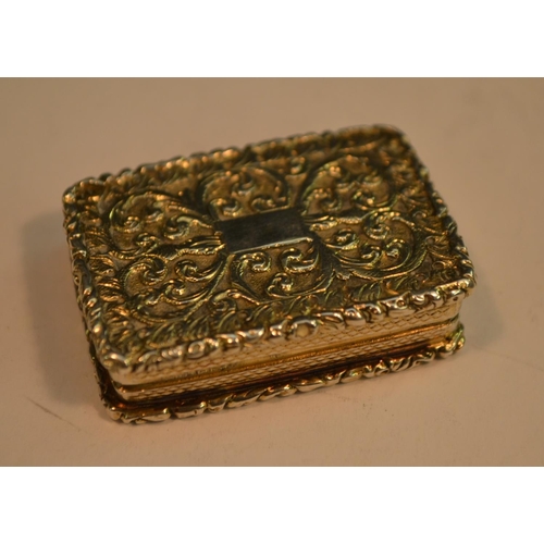 707 - A George IV silver-gilt rounded rectangular vinaigrette, cast throughout with scrolling foliage, hin... 