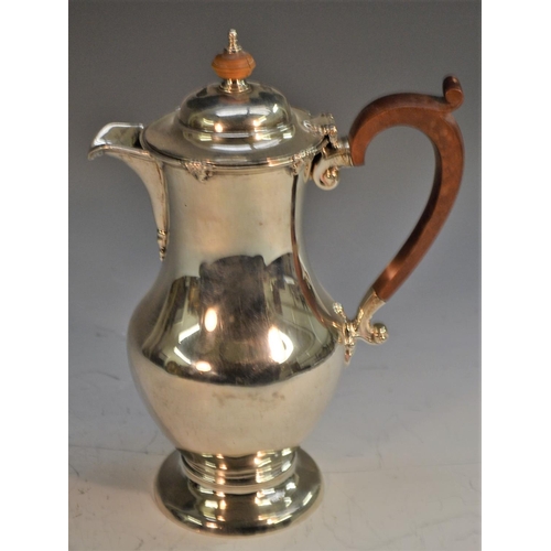 713 - A George V silver baluster hot water pot, hinged domed cover, scroll-capped handle, domed foot, 23cm... 