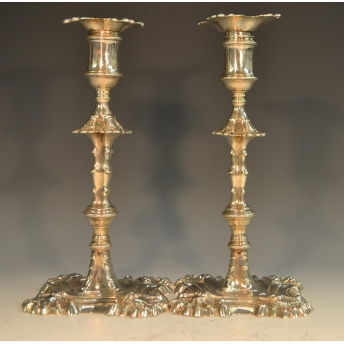 748 - A matched pair of George III cast silver table candlesticks, of seamed consrtruction, detachable noz... 