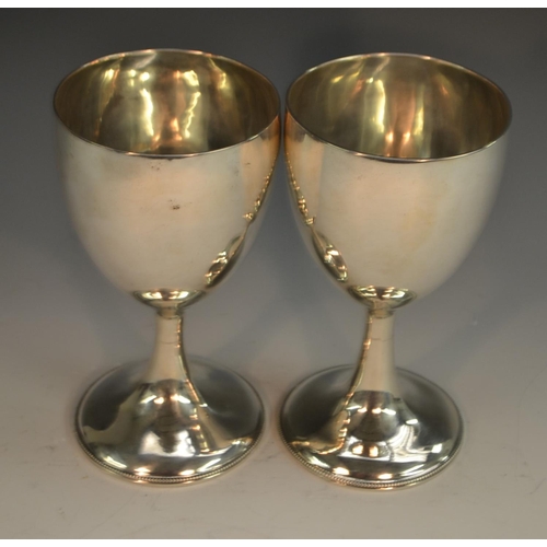 757 - A pair of George III Irish silver ovoid pedestal goblets, quite plain, spreading bases with beaded b... 