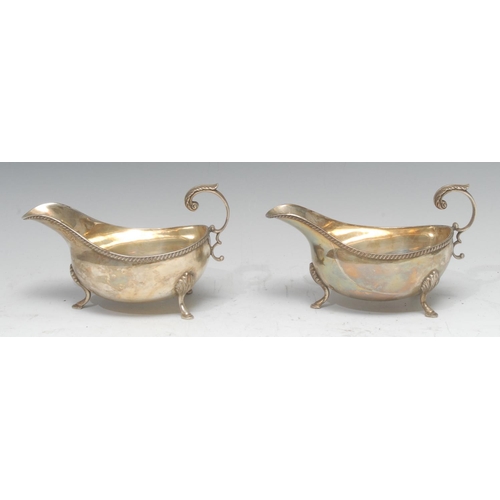 759 - A pair of George III style silver sauce boats, gadrooned rims, flying acanthus capped scroll handles... 