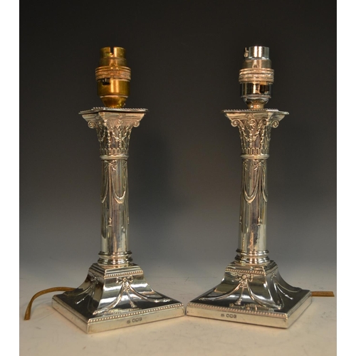 760 - A pair of George V Neo-Classical Revival silver table lamps, converted from candlesticks, embossed w... 