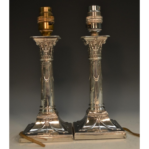 760 - A pair of George V Neo-Classical Revival silver table lamps, converted from candlesticks, embossed w... 