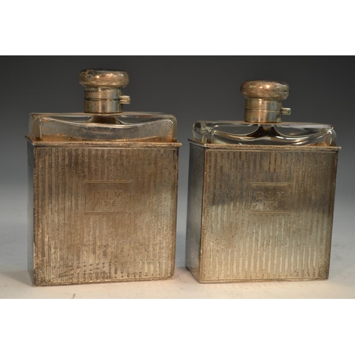 762 - A pair of George V silver slip-cased flasks, hinged domed covers, engine turned in bands, 12.5cm hig... 