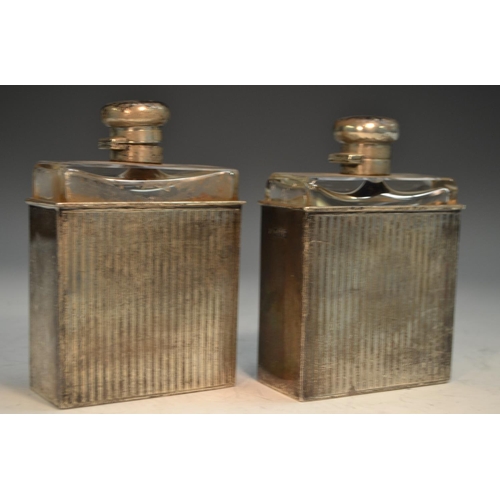 762 - A pair of George V silver slip-cased flasks, hinged domed covers, engine turned in bands, 12.5cm hig... 