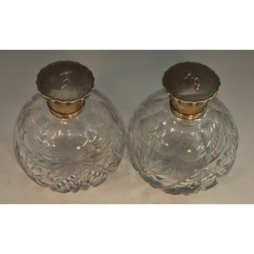 768 - A pair of Spanish silver mounted cut-clear glass globular scent bottles, push-fitting covers enclosi... 