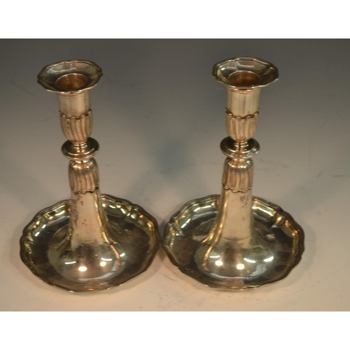 770 - A pair of Swiss silver candlesticks, detachable nozzles, dished trumpet shaped bases with shaped bor... 