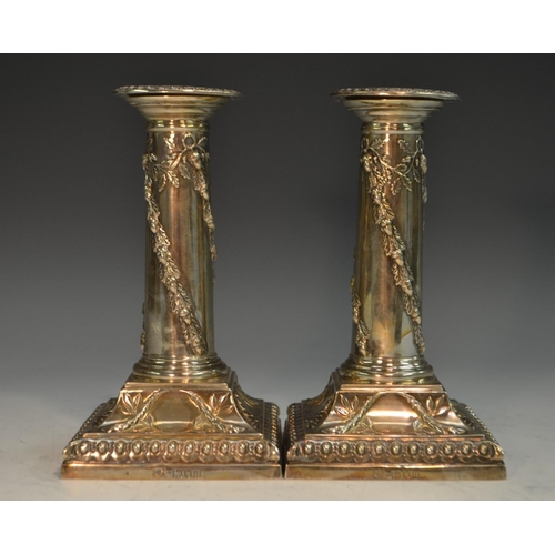 771 - A pair of Victorian Adam Revival silver columnar candlesticks, each embossed with spiral-bands of fr... 