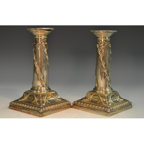 771 - A pair of Victorian Adam Revival silver columnar candlesticks, each embossed with spiral-bands of fr... 