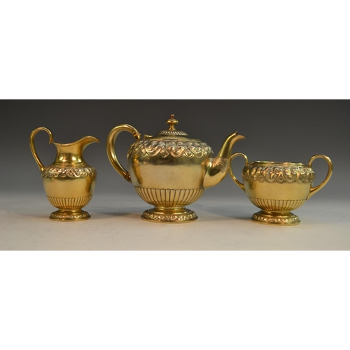 821 - A Victorian silver-gilt bachelor's tea service, comprising bullet shaped teapot, milk jug and sugar ... 