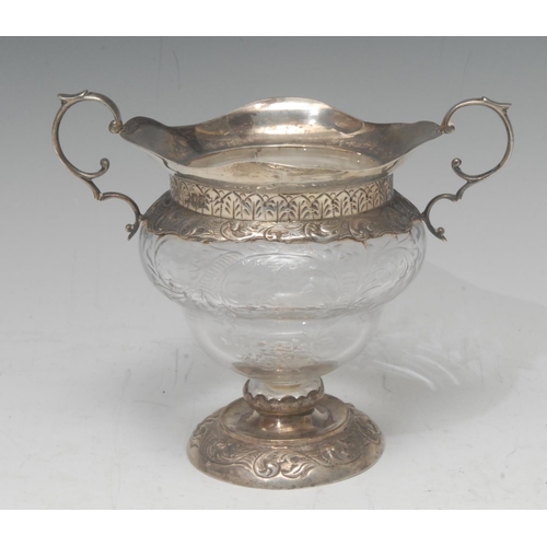 822 - A Victorian two-handled silver mounted ogee class bowl, etched with foliate swags, the mounts emboss... 