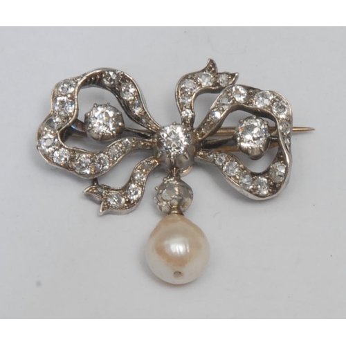 986 - A late 19th/early 20th century diamond and pearl ribbon bow brooch, tied bow white metal frame inset... 