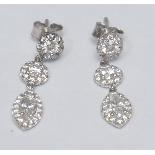 988 - A pair of diamond droplet earrings, each with a principle droplet of a central navette diamond surro... 