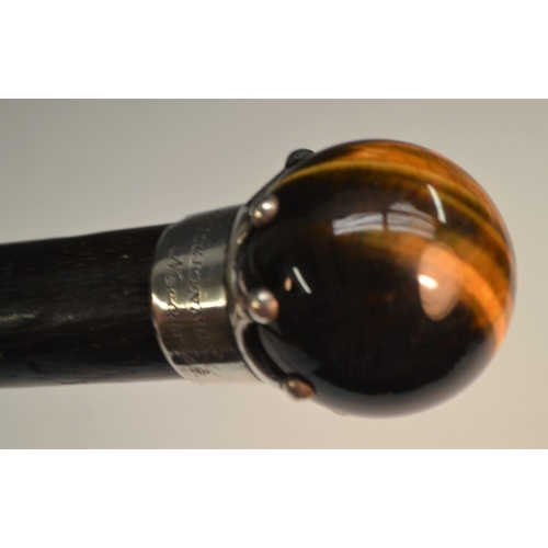 1174 - A 19th century tiger's eye and silver coloured metal mounted gentleman's walking cane, claw-set glob... 