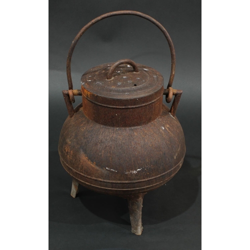 1319 - A 19th century cast iron tripod cauldron and cover, swing handle, outswept legs, 43cm high