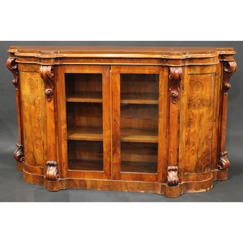 1639 - A Victorian walnut shaped serpentine credenza, moulded top above a pair of rectangular glazed doors ... 