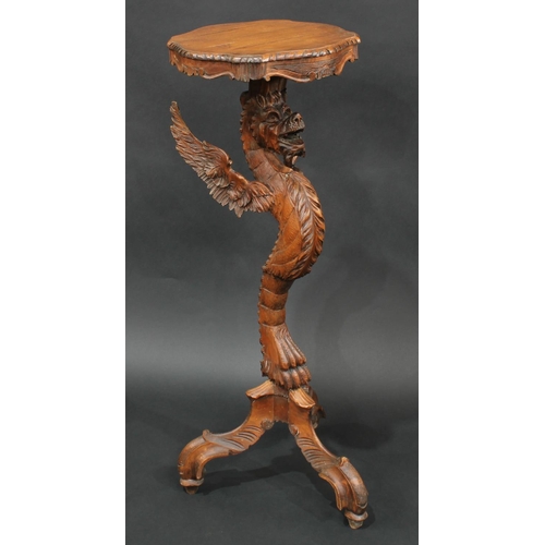 2063 - A Venetian limewood tripod torchere, boldly carved as a dragon monopodia, shaped serpentine plateau,... 