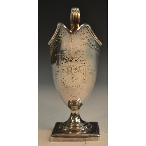 696 - A George III silver helmet shaped cream jug, bright-cut engraved and outlined throughout with wriggl... 