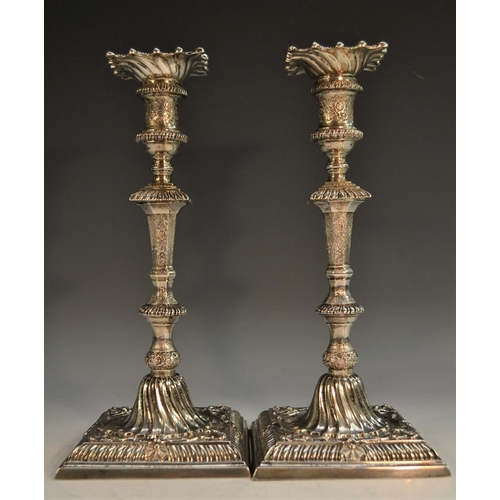 755 - A pair of George III cast silver table candlesticks, of seamed construction, spirally fluted nozzles... 