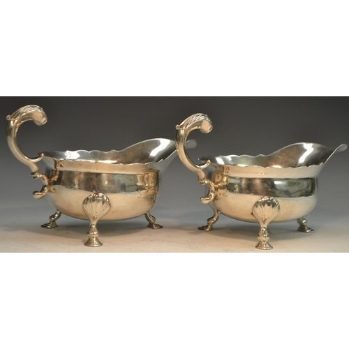 764 - A pair of large George II silver sauce boats, acanthus-capped flying scroll handles, shaped borders,... 