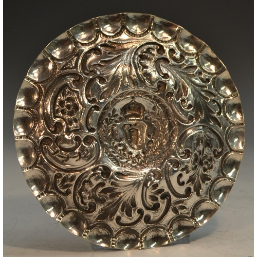 774 - A Portuguese silver coloured metal circular dish, chased with flowers and scrolling foliage, the rai... 