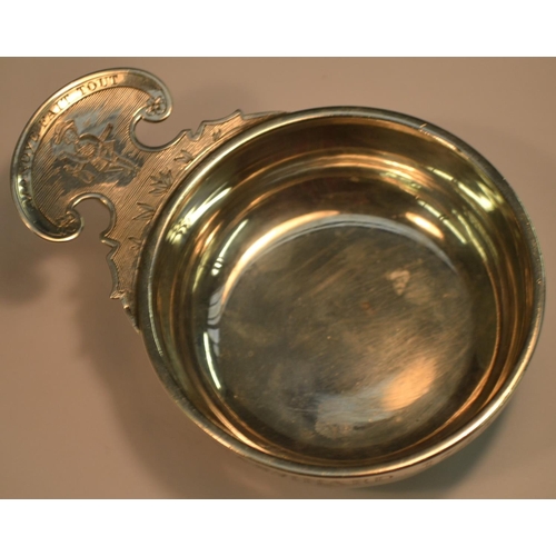 837 - An 18th century French silver wine taster, of heavy gauge, ring and shaped-lug handle bright-cut eng... 