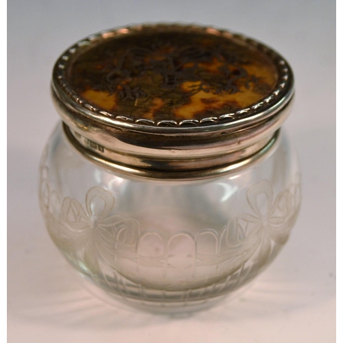 874 - An Edwardian silver, tortoiseshell and pique mounted clear glass dressing table jar, the push-fittin... 