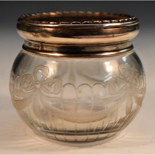 874 - An Edwardian silver, tortoiseshell and pique mounted clear glass dressing table jar, the push-fittin... 