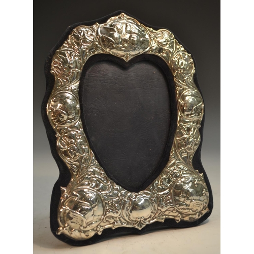 877 - An Elizabeth II silver heart shaped easel photograph frame, embossed with Reynolds angels and Art No... 