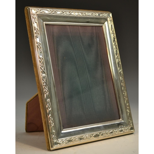 878 - An Elizabeth II silver rectangular easel photograph frame, the border embossed in the Celtic taste, ... 