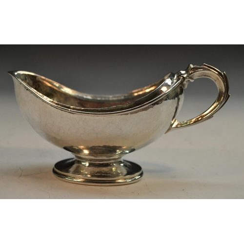 909 - Omar Ramsden - an Arts and Crafts silver boat shaped pedestal sugar basin, domed foot, scroll handle... 