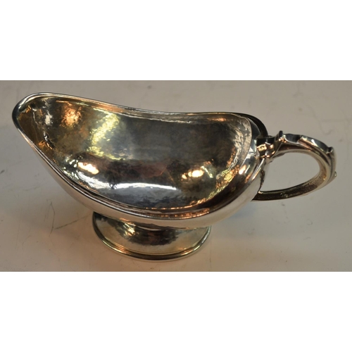 909 - Omar Ramsden - an Arts and Crafts silver boat shaped pedestal sugar basin, domed foot, scroll handle... 