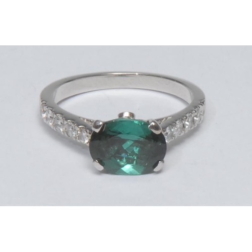 995 - A tourmaline and diamond ring, central oval deep blue-green indicolite tourmaline quarter claw set a... 