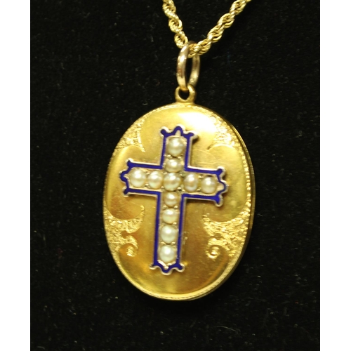 5708 - A Victorian gold coloured metal oval locket, applied with a blue enamel and seed pearl cross, engrav... 