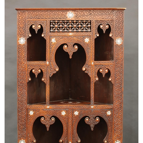 1641 - A Moorish hardwood and marquetry open corner vitrine, shallow cornice above an arrangement of mirhab... 