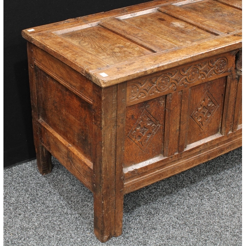 1289 - A 17th century oak blanket chest,  above a four panel front carved with lozenges, stile feet, 117cm ... 