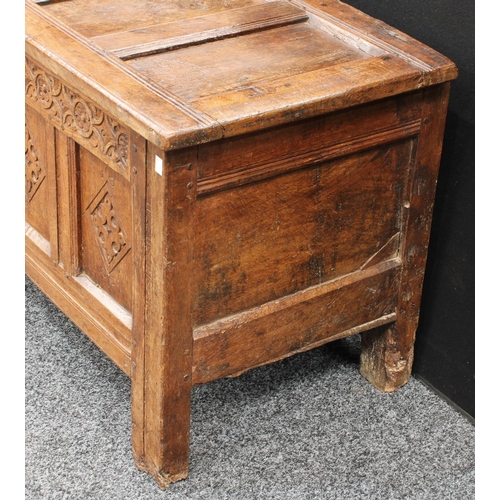 1289 - A 17th century oak blanket chest,  above a four panel front carved with lozenges, stile feet, 117cm ... 